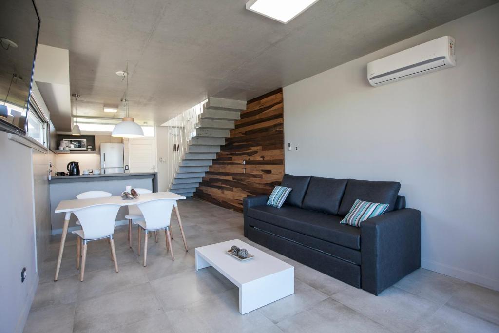 a living room with a black couch and a table at Nova pampa apart&spa in Mar de las Pampas