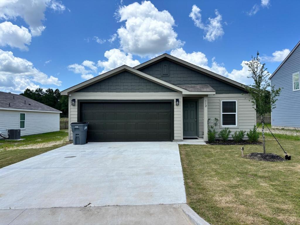 a house with a large garage in a yard at Quiet at Pine Branch in Lufkin