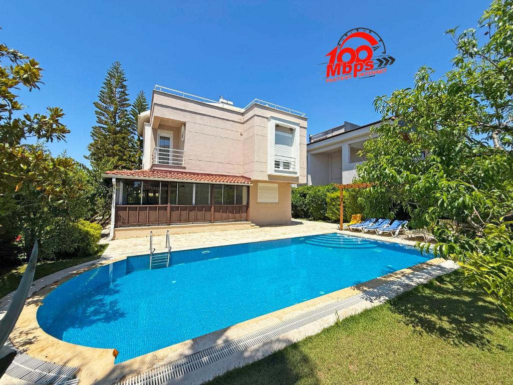 a swimming pool in front of a house at Paradise Town Villa Royal in Belek