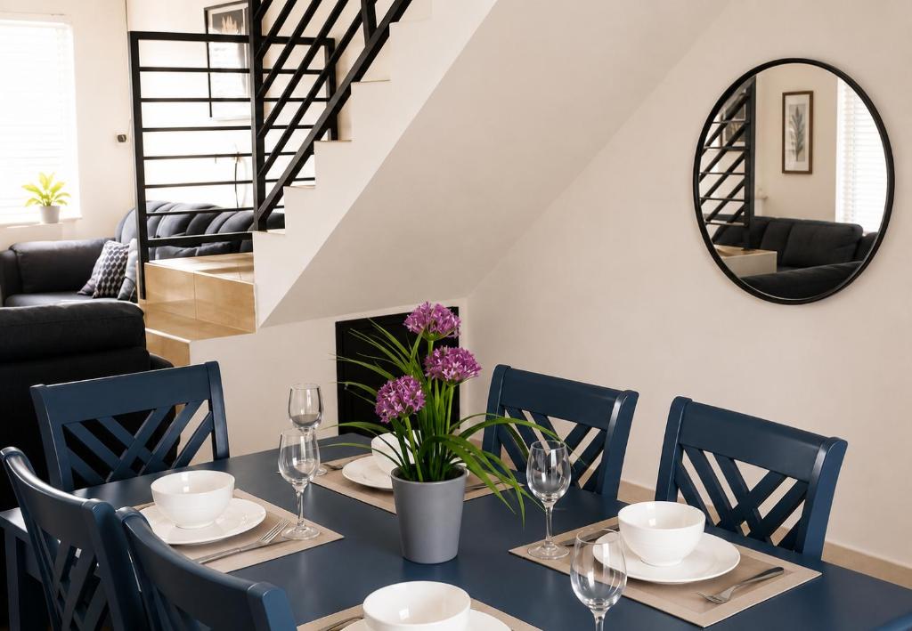a dining room with a table with chairs and a mirror at Glenmuir La Ville - Gated Com May Pen in May Pen