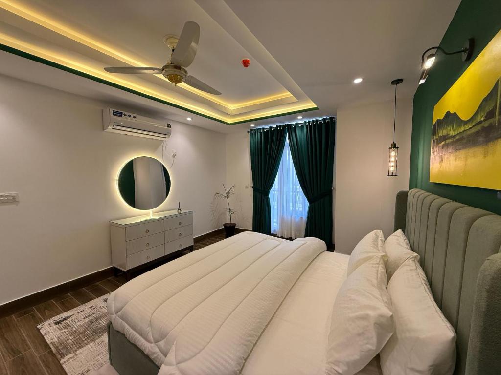a bedroom with a large bed and a mirror at 2 BHK Stayloom 218 in Rawalpindi