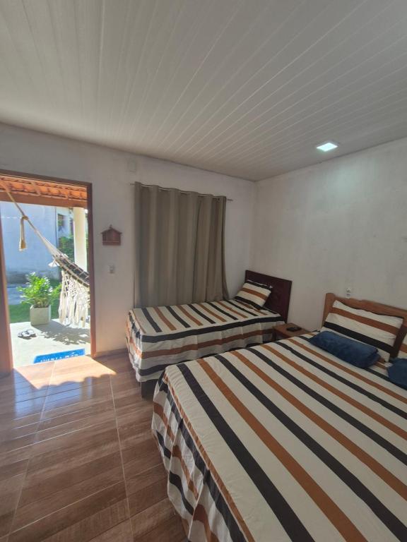 two beds in a room with a view of the ocean at Chalés Brisa do Mar in Amontada