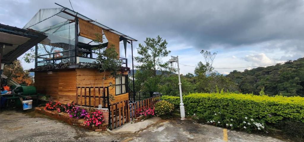a building with a balcony and flowers on it at Sameer Mountain View Retreat in Tanah Rata
