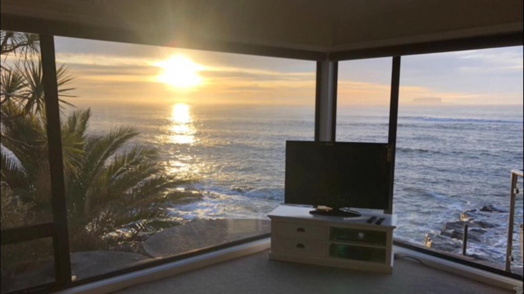 a living room with a view of the ocean at Stanley View Beach House in Crayfish Creek