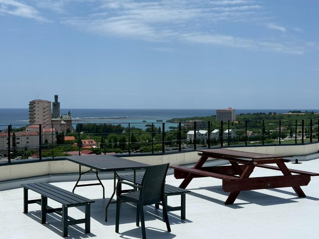 a patio with two picnic tables and chairs on a roof at Villa resort -悠- in Miyakojima