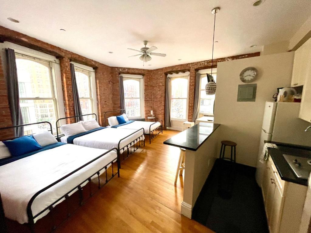 a room with three beds and a kitchen with windows at Empire State & nest in New York