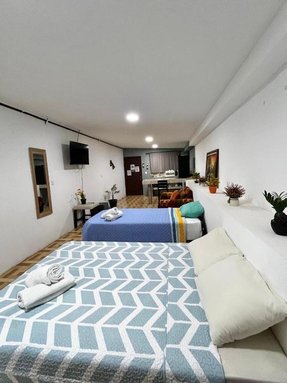 a bedroom with two beds and a living room at Apartamento El Almendro in Liberia