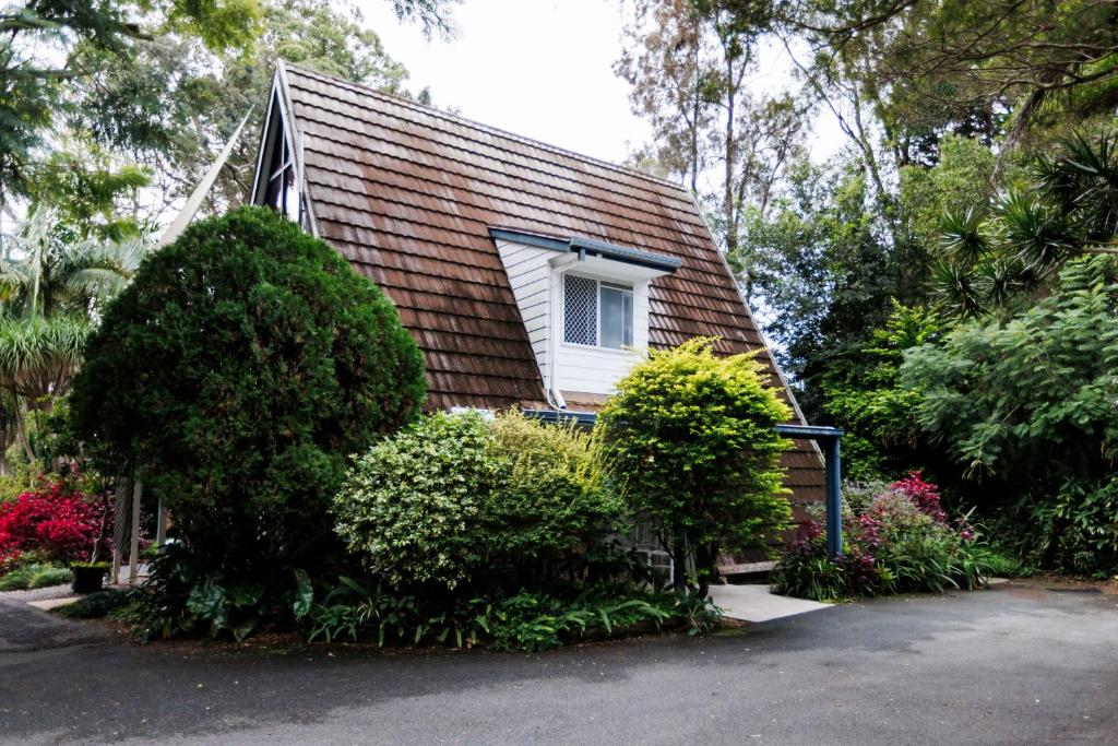 a small house with a window and some bushes at Family & Friends Cottage in Mount Tamborine