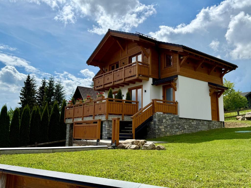 a large wooden house with a balcony on a lawn at Villa Bergbliss in Bukovel