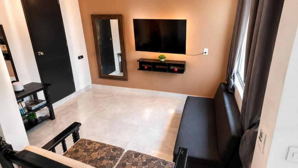 a living room with a flat screen tv on the wall at Departamentos Aurora in Tuxtla Gutiérrez
