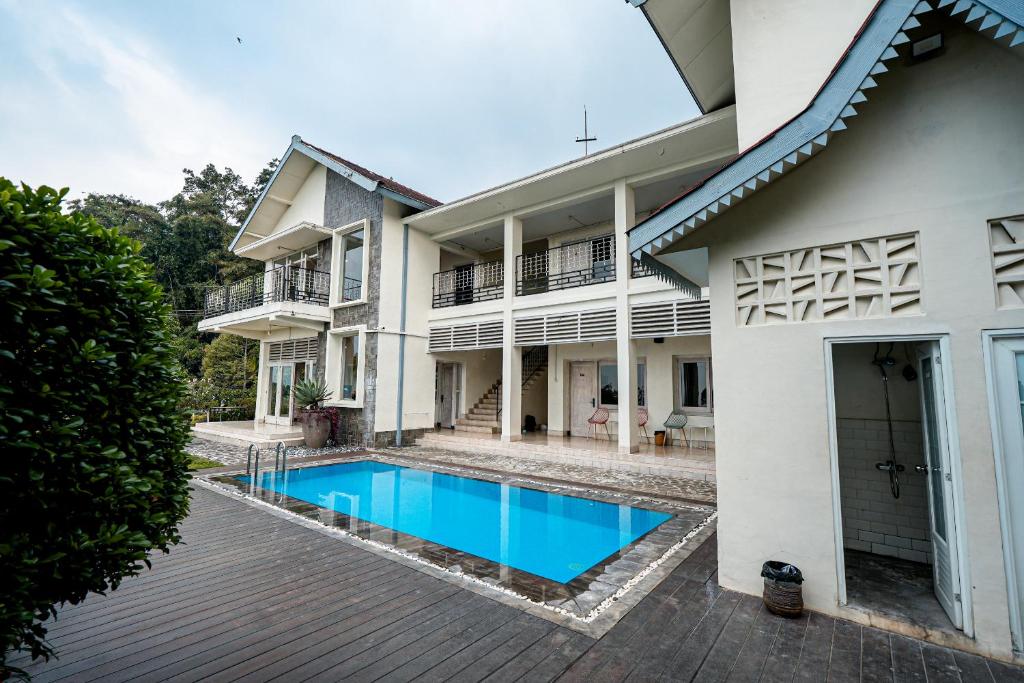 an exterior view of a house with a swimming pool at Wisma Nirwana Tretes near Cimory Prigen in Prigen