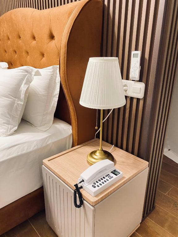 a lamp on a table next to a bed with a phone at The Heaven Royal Glamp in Bedakah