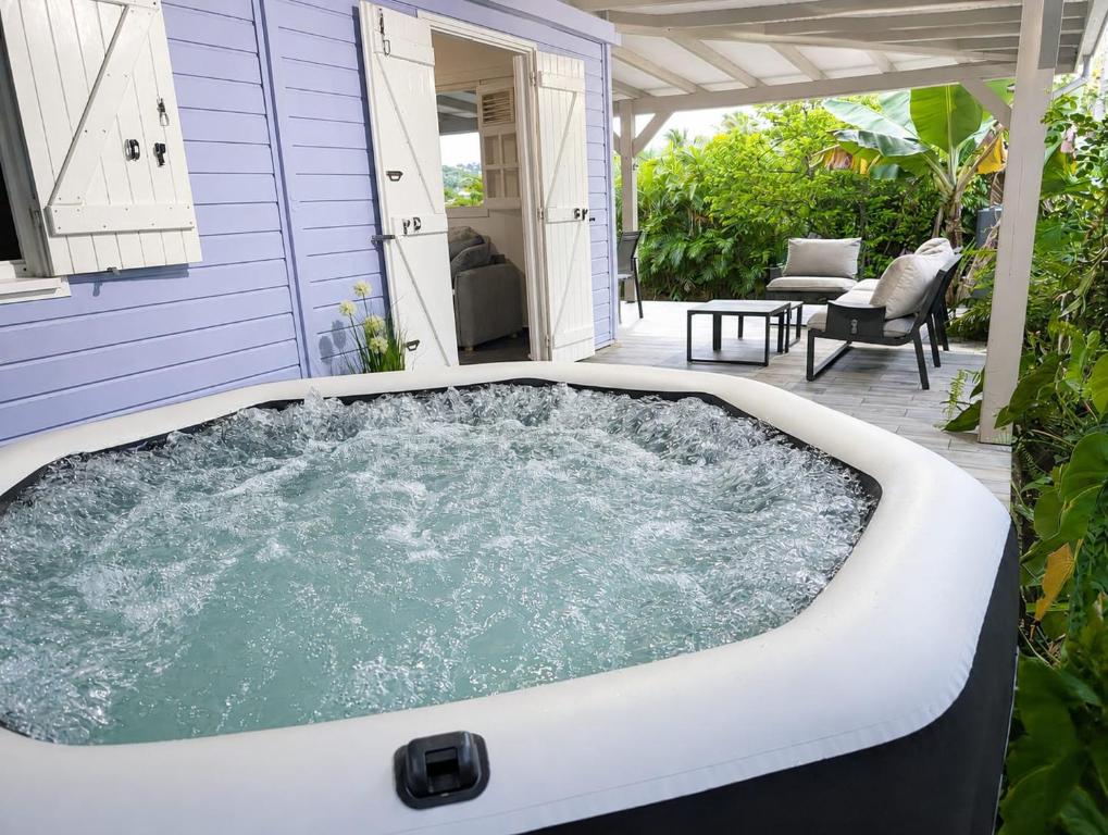 a hot tub on the patio of a house at Villa 6 pers Jacuzzi Centre Guadeloupe in Petit-Bourg
