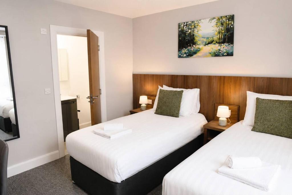 a hotel room with two beds and a mirror at Coach House Accommodation - Room 2 in Carrick on Shannon