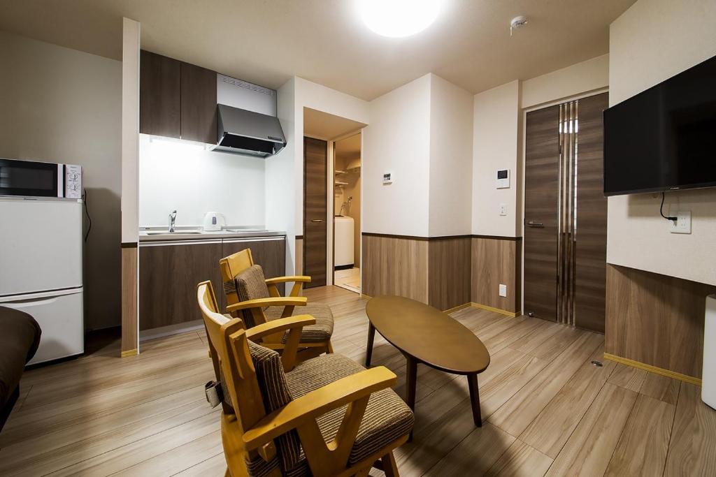 a living room with a table and chairs and a kitchen at 萩別邸 シーサイド1 HAGI Bettei SEASIDE1 in Hagi