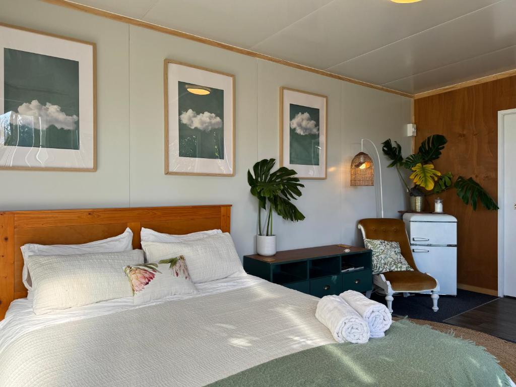 a bedroom with a bed and a desk and a chair at Pōhutukawa Studio in Tauranga