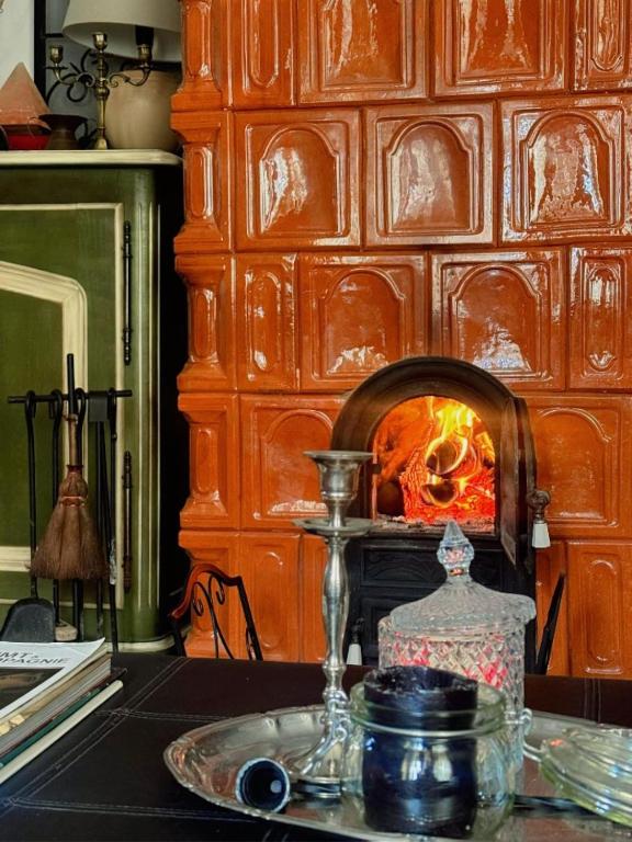 a table with a plate and a fire in a fireplace at Bohemian Chalet in Buşteni