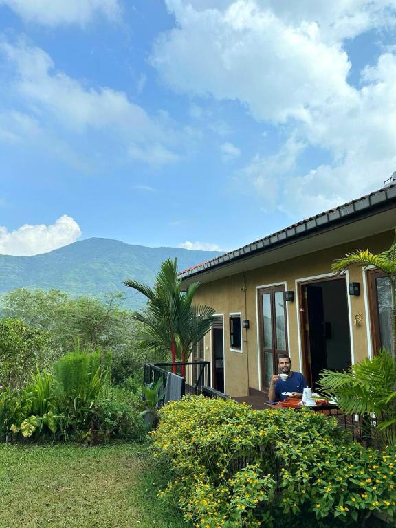 a person sitting at a table outside of a house at Riverston Hideaway in Matale