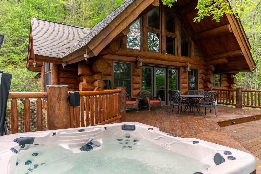a large hot tub on the deck of a log cabin at Buffalo Creek Lodge in West Jefferson