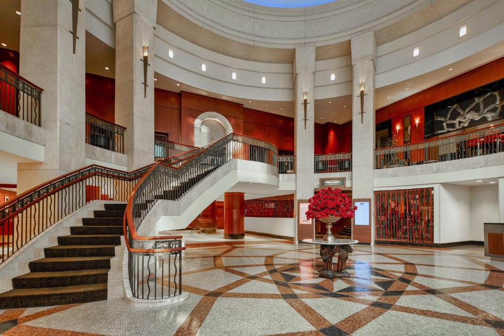 a lobby with stairs and a vase of red flowers at InterContinental Chicago Magnificent Mile by IHG in Chicago