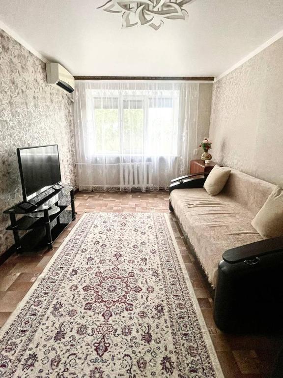 a living room with a couch and a rug at Квартира 2х ком на Амангельды 1 in Balqash