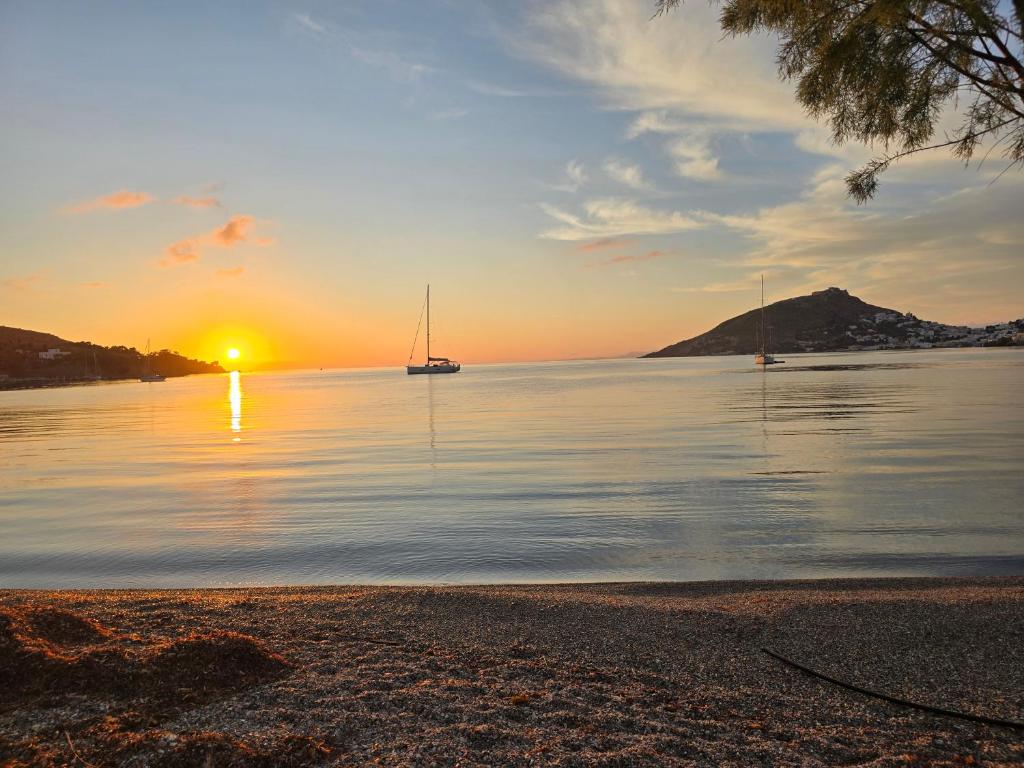 a sunset on a lake with boats in the water at Tony's Rooms in Alinda