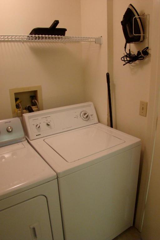 a laundry room with a washing machine and a shelf at Vanderbilt Beach Resort in Naples