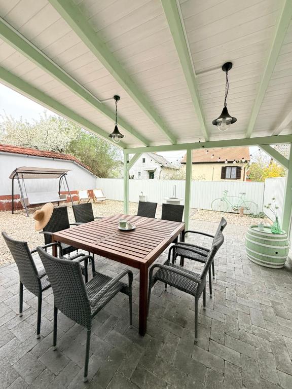 a wooden table and chairs on a patio at Helló Zsóry Apartman in Mezőkövesd