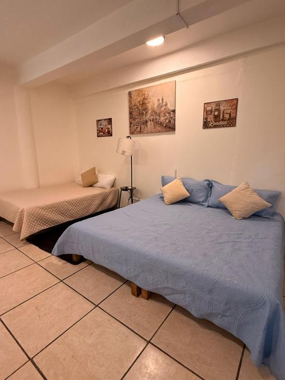 a bedroom with two beds and a lamp in it at Beit Shalom habitaciones con clima in Orizaba