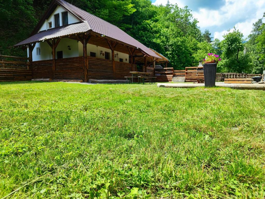 a wooden cabin with a gazebo in a field at River Haus in Călineşti
