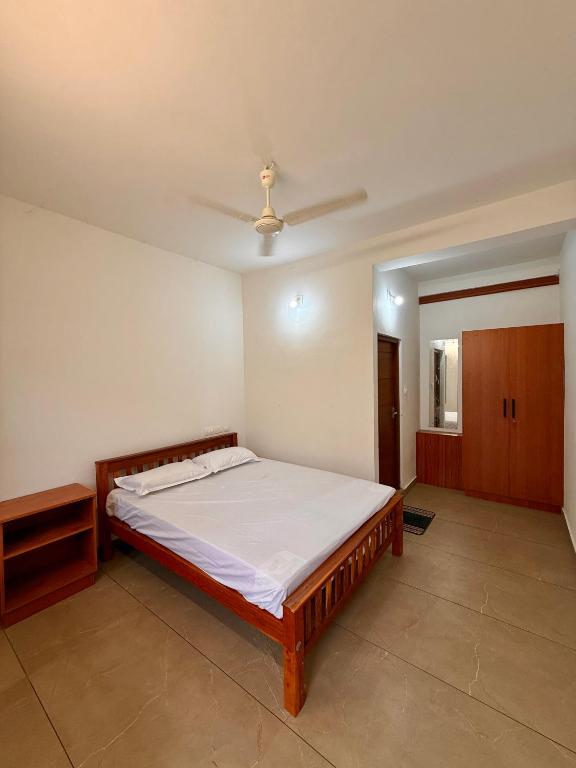 a bedroom with a bed and a dresser in it at IB homes in Changanācheri