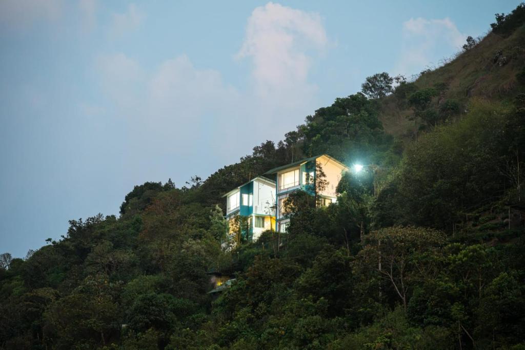 a house on the side of a hill with lights at The Cloud by Daan in Vagamon