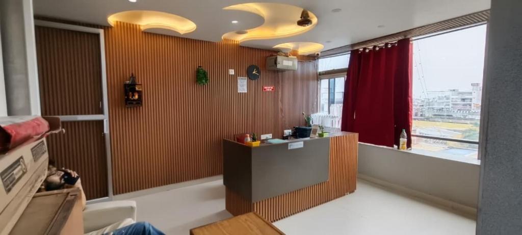a kitchen with a counter and a red curtain at Hotel sunshine in Kānpur