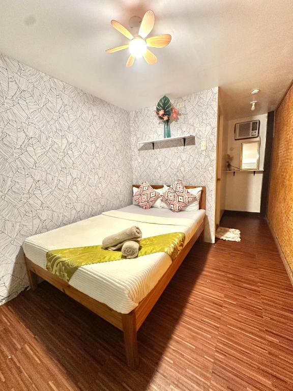 a bedroom with a bed with a ceiling fan at Amancio's Tourist Inn-Close to the Airport in Puerto Princesa City