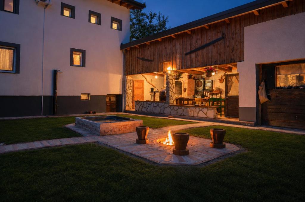 a backyard with a fire pit next to a house at Lakuša Retreat in Latin