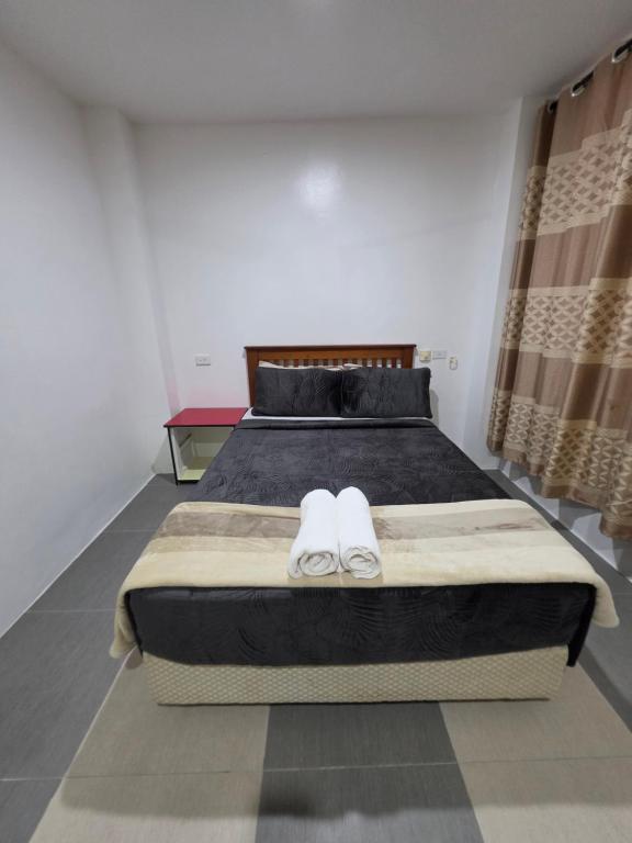 a bedroom with a bed with two white slippers at 77 Fulaga Flats in Suva