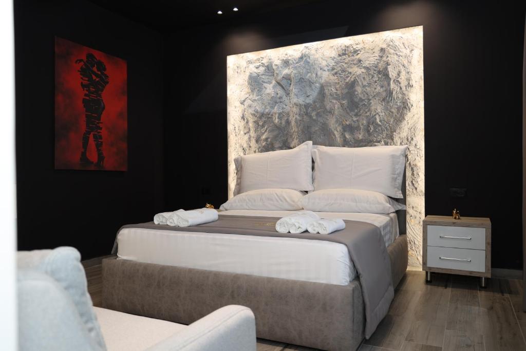 a bedroom with a large bed with white pillows at Darius Hotel in Shkodër