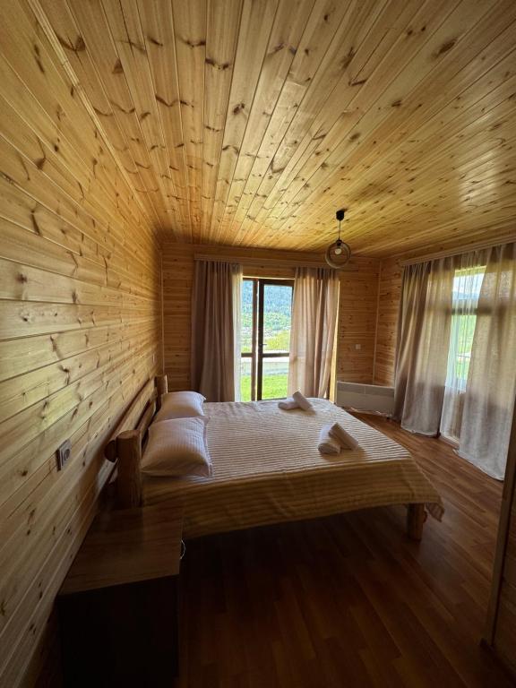 a bedroom with a bed in a wooden wall at Ivlita in Mestia