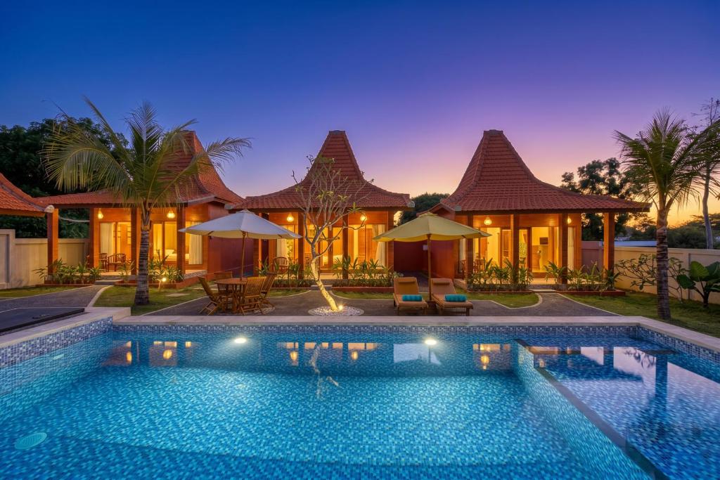 a swimming pool in front of a villa at Wigus Villa Melasti in Ungasan