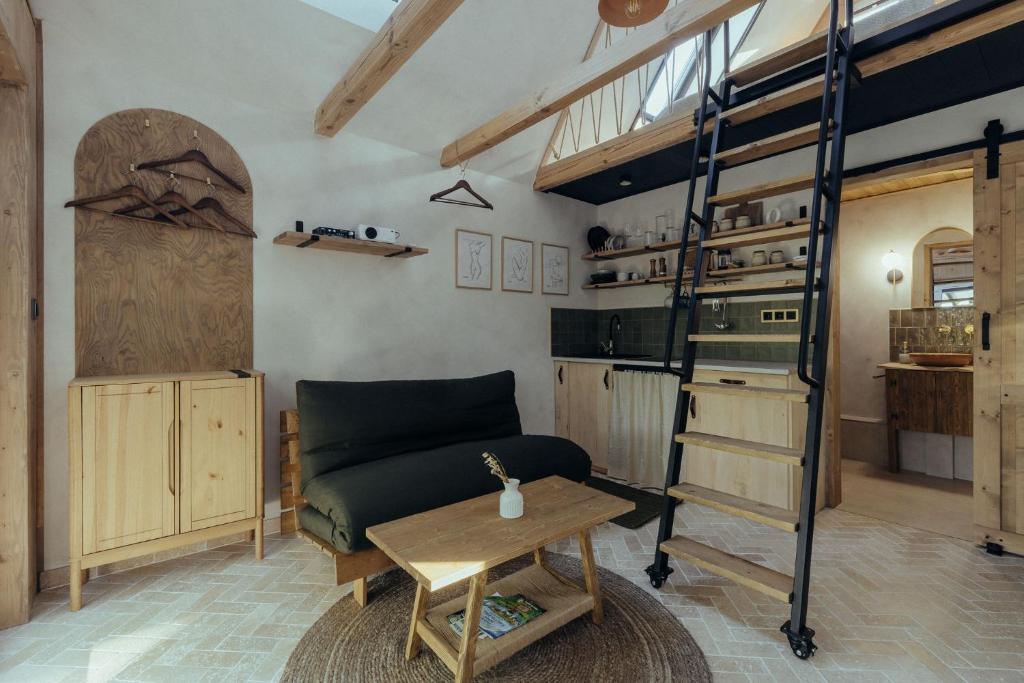a living room with a loft bed and a table at A Házikó in Balatonederics
