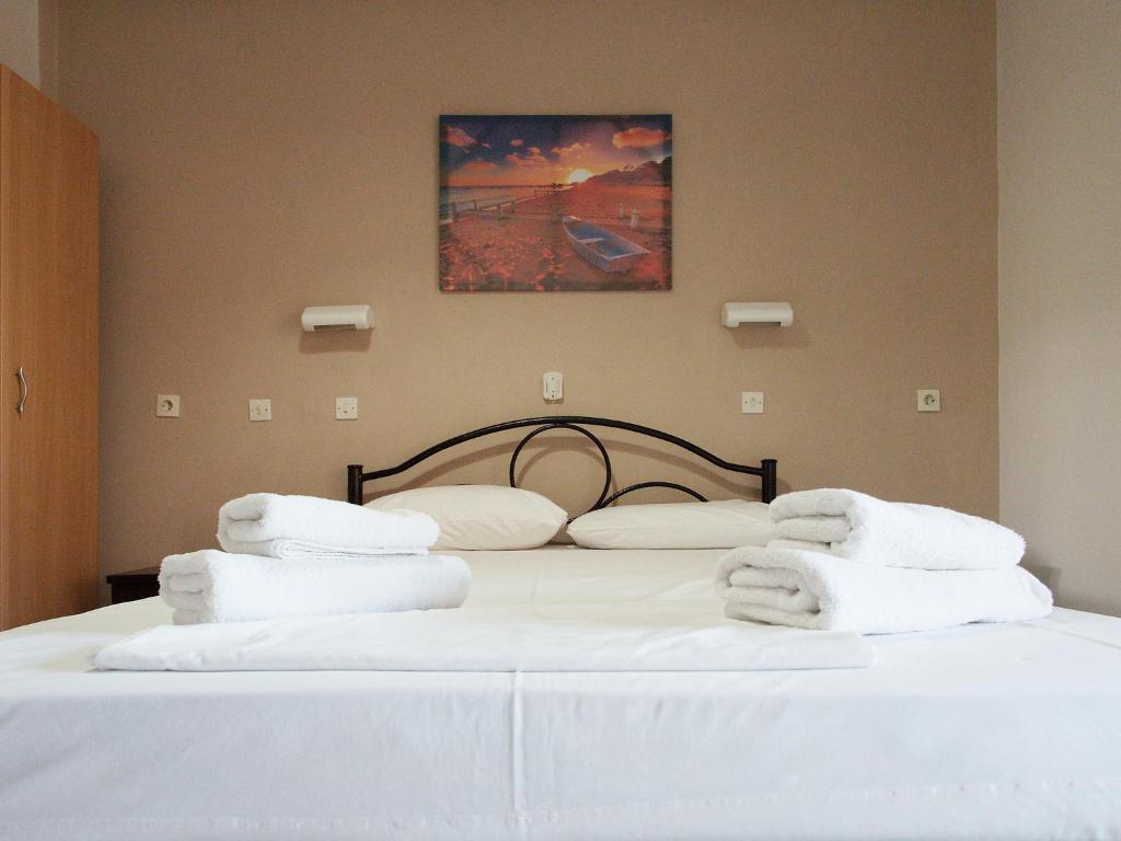 a bedroom with a bed with white towels on it at Rose Garden in Melíkia
