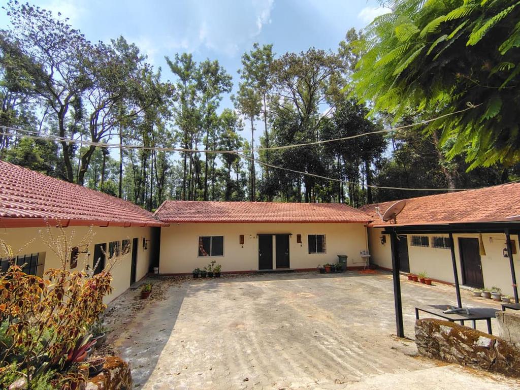 a house with red roofs and a courtyard at Outbackwoods homestay room Robusta in Vastāra