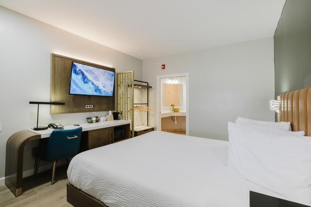 a hotel room with a bed and a desk and a television at SureStay by Best Western Morgan Hill in Morgan Hill