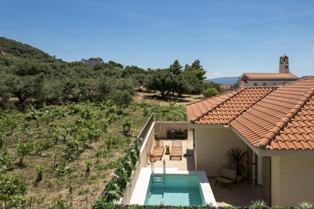 an external view of a house with a swimming pool at Anthos Villa in Kardhakáta