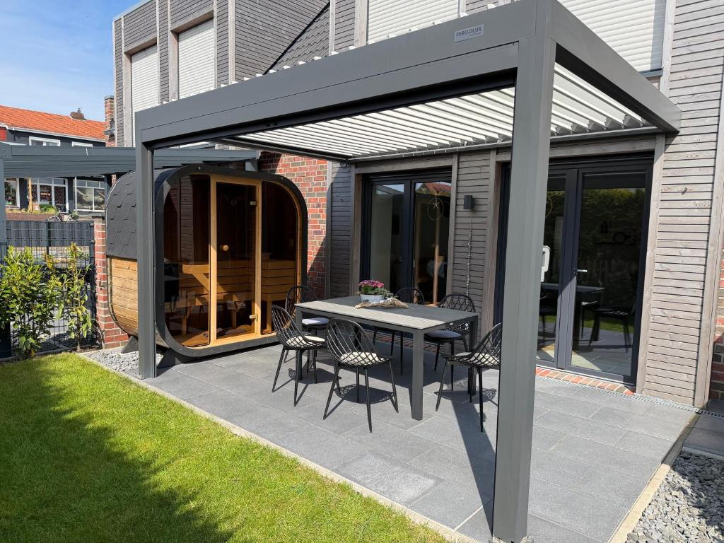 a patio with awning and a table and chairs at MeerZeit 20 in Carolinensiel