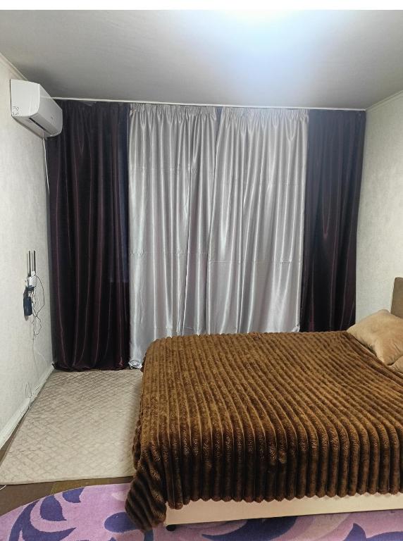 a bedroom with a bed and a large window at 2 кімнатні апартаменти в центрі міста in Pavlohrad