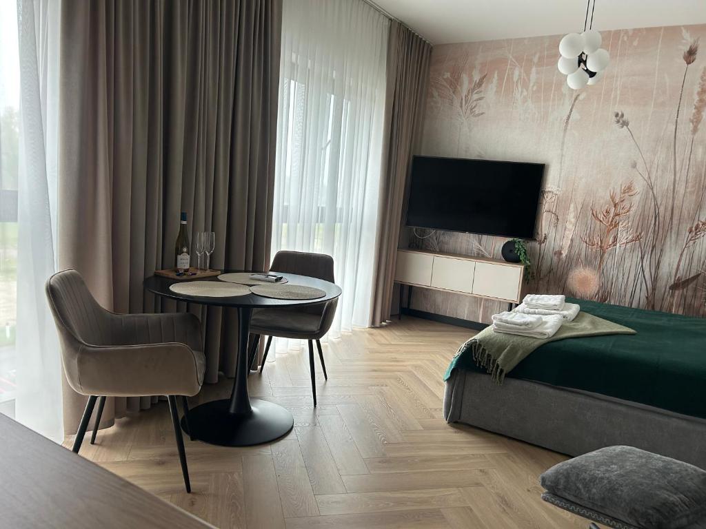 a bedroom with a table and a bed and a dining room at Horizon Park Lux II in Boszkowo-Letnisko