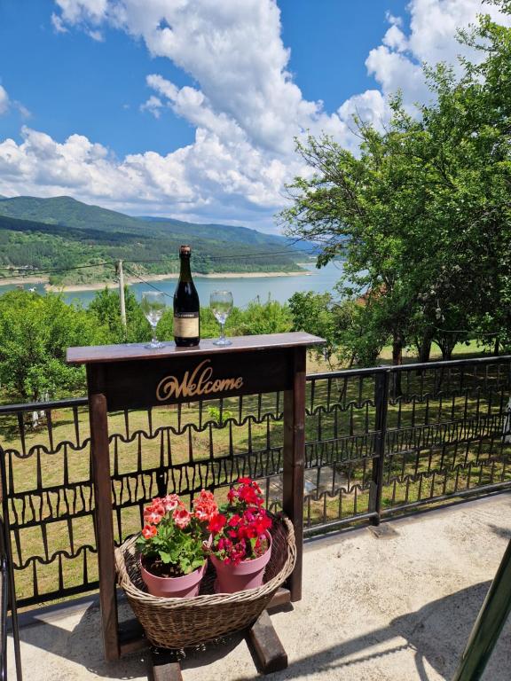 a bottle of wine sitting on a table with flowers at Zavojsko jezero View - kuća Mitić in Pirot