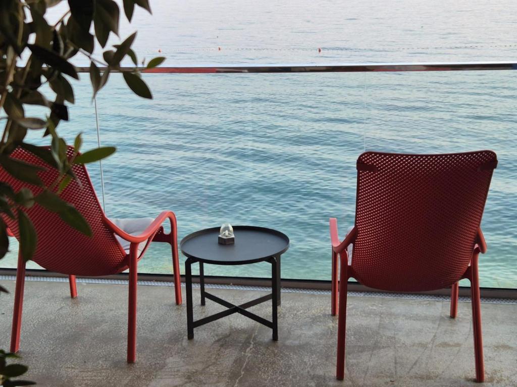 two chairs and a table with a tea pot on top of it at Apartments Zanic on The Beach in Podstrana