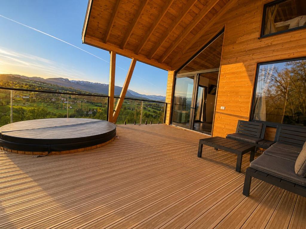 a deck with a table and chairs on a house at Royal Hill-Prince Chalet Bran- Mountain View and Hot Tub in Sohodol